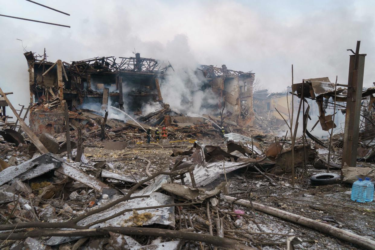 Firefighters spray water on a destroyed shoe factory following an airstrike in Dnipro on March 11, 2022. (Emre Caylak/AFP via Getty Images)