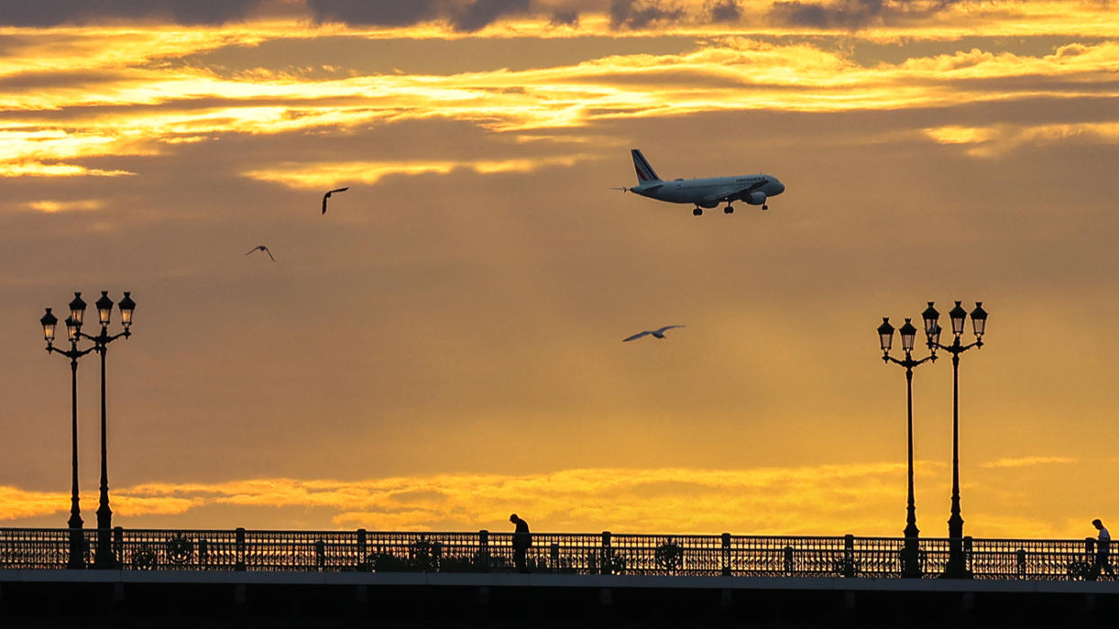 An Air France plane in the sky at sunset.