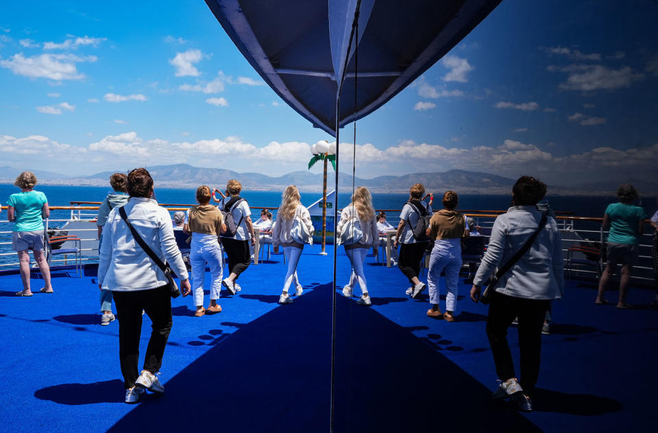 Travelers on the deck of a cruise ship (Mehmet Emin Menguarslan / Anadolu via Getty Images)