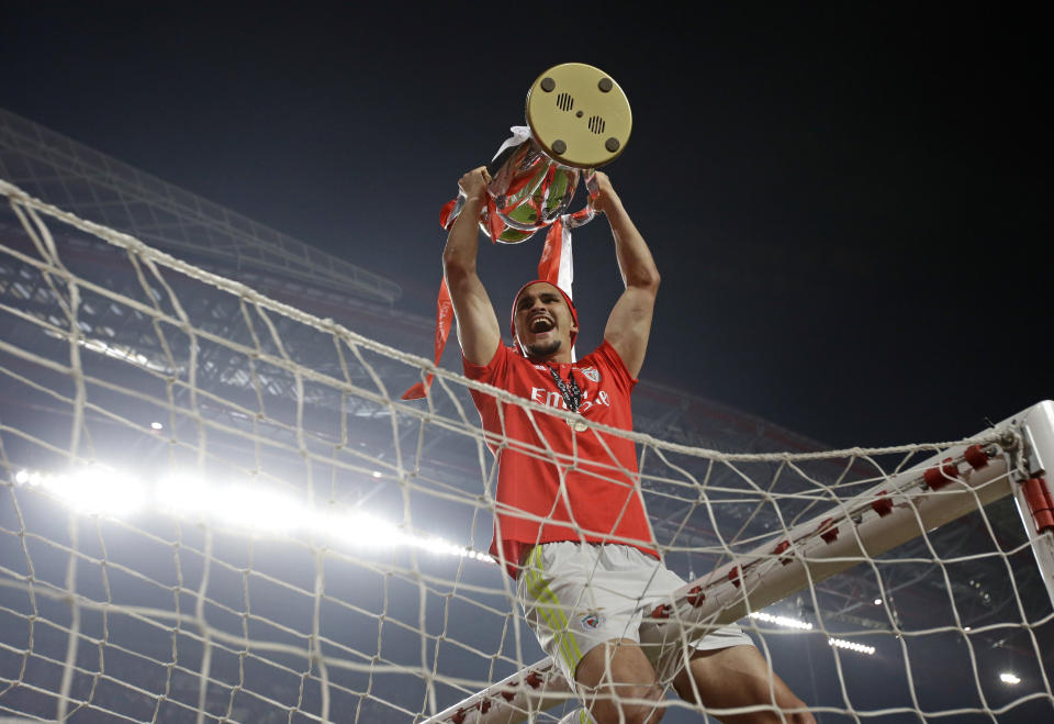 Benfica goalkeeper Ivan Zlobin holds the trophy atop the goal after the Portuguese league last round soccer match between Benfica and Santa Clara at the Luz stadium in Lisbon, Saturday, May 18, 2019. Benfica won 4-1 to clinch the championship title. (AP Photo/Armando Franca)