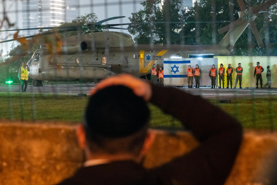 An orthodox Jewish man watches as a helicopter with Israeli hostages released earlier by Hamas lands at Schneider medical center on the third day of the temporary truce where they disembarked behind screens as family and friends wait nearby, Nov. 26, 2023 in Petah Tivka, Israel. / Credit: Alexi Rosenfeld/Getty