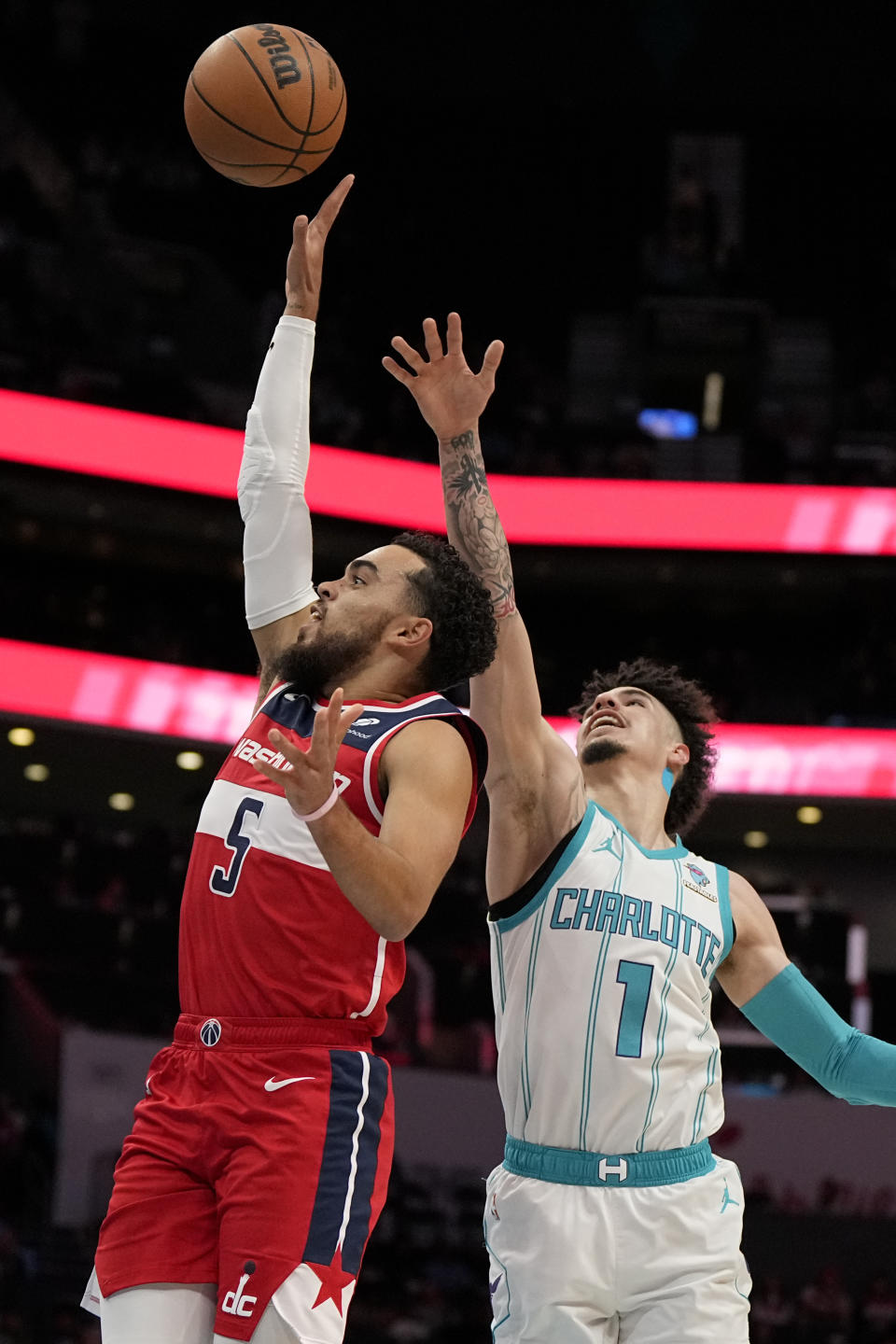 Washington Wizards guard Tyus Jones shoots past Charlotte Hornets guard LaMelo Ball during the first half of an NBA basketball game on Wednesday, Nov. 22, 2023, in Charlotte, N.C. (AP Photo/Chris Carlson)