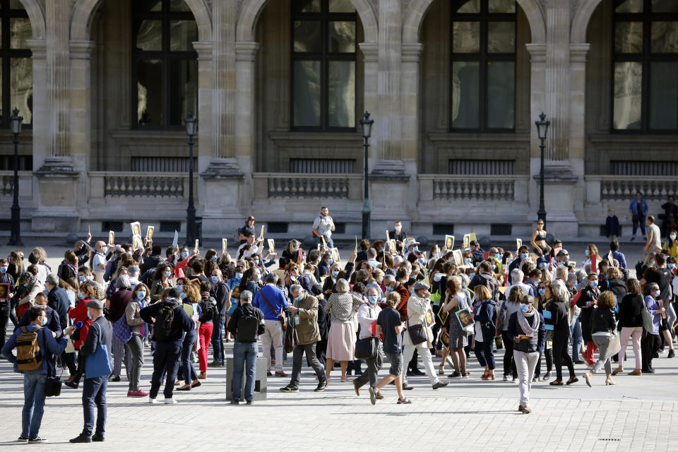 Guide speakers demonstrate to warn about their financial situation in front of the Louvre Museum, in Paris, Monday, July 6, 2020. The home of the world's most famous portrait, the Louvre Museum in Paris, reopened Monday after a four-month coronavirus lockdown. (AP Photo/ Thibault Camus)