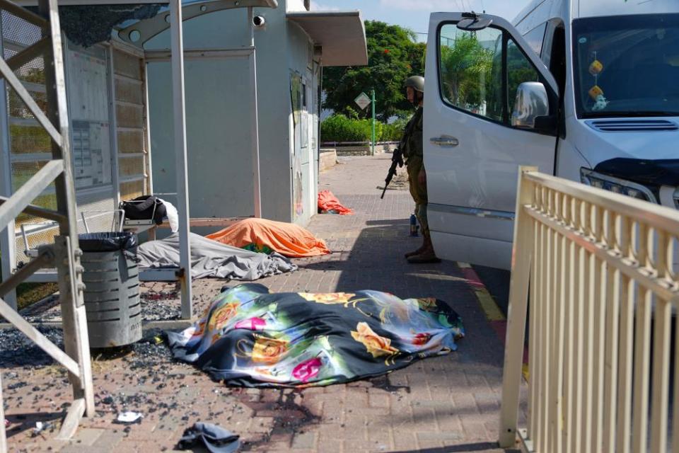 Israeli soldier stands by bodies