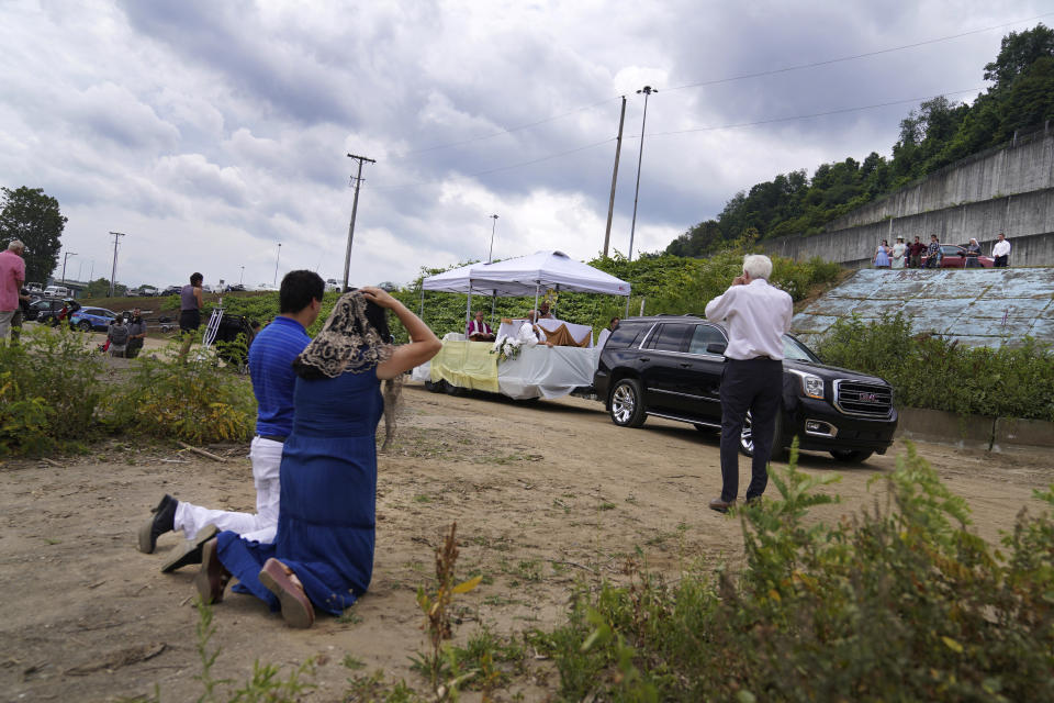 Catholics kneel as the Eucharist arrives at the Steubenville Marina in Steubenville, Ohio, Sunday, June 23, 2024. (AP Photo/Jessie Wardarski)