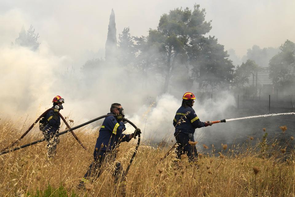 Firefighters try to extinguish a fire in Kapandriti village, about 38 kilometres (23 miles) north of Athens, Greece, Friday, Aug. 6, 2021. Thousands of people fled wildfires burning out of control in Greece and Turkey on Friday, as a protracted heat wave turned forests into tinderboxes and flames threatened populated areas, electricity installations and historic sites. (AP Photo/Thanassis Stavrakis)