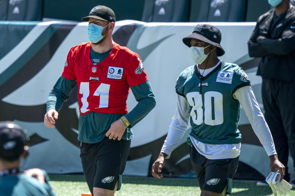 Philadelphia Eagles quarterback Carson Wentz, left, comes out to the field with wide receiver Quez Watkins, right, during an NFL football practice, Sunday, Aug. 30, 2020, in Philadelphia. (AP Photo/Chris Szagola, Pool)