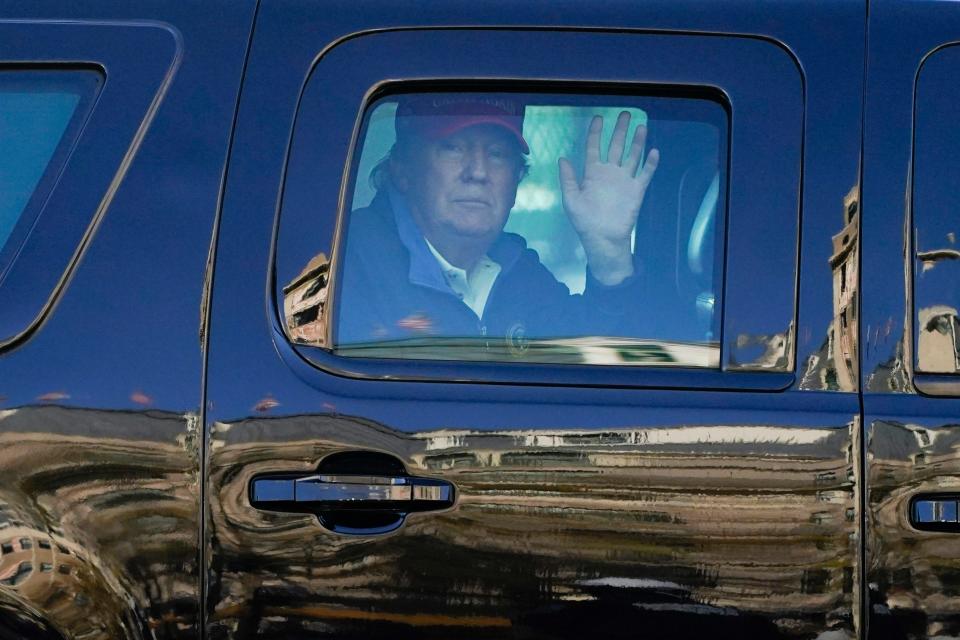 President Donald Trump waves to supporters from his motorcade as people gather for a march Nov. 14, 2020, in Washington.