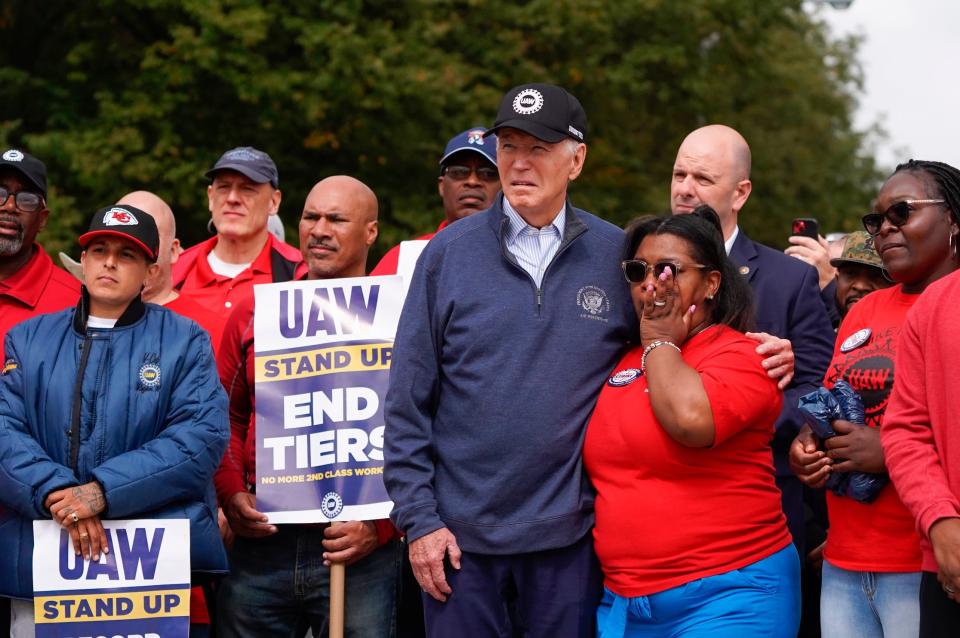 President Joe Biden listens to UAW president Shawn Fain speak as he stands with workers picketing at General Motors Willow Run Redistribution in Belleville on Tuesday, September 26, 2023, during a stop in Michigan.