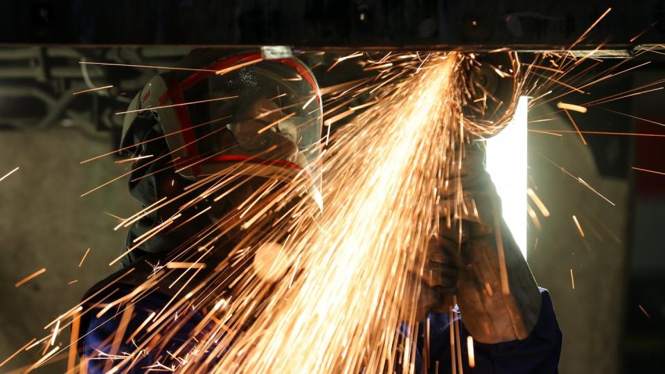 Ein Mitarbeiter eines Maschinenbauunternehmens schneidet Metallteile. Die Bestellungen bei Deutschlands Maschinenbauern gingen im April um 31 Prozent zurück.