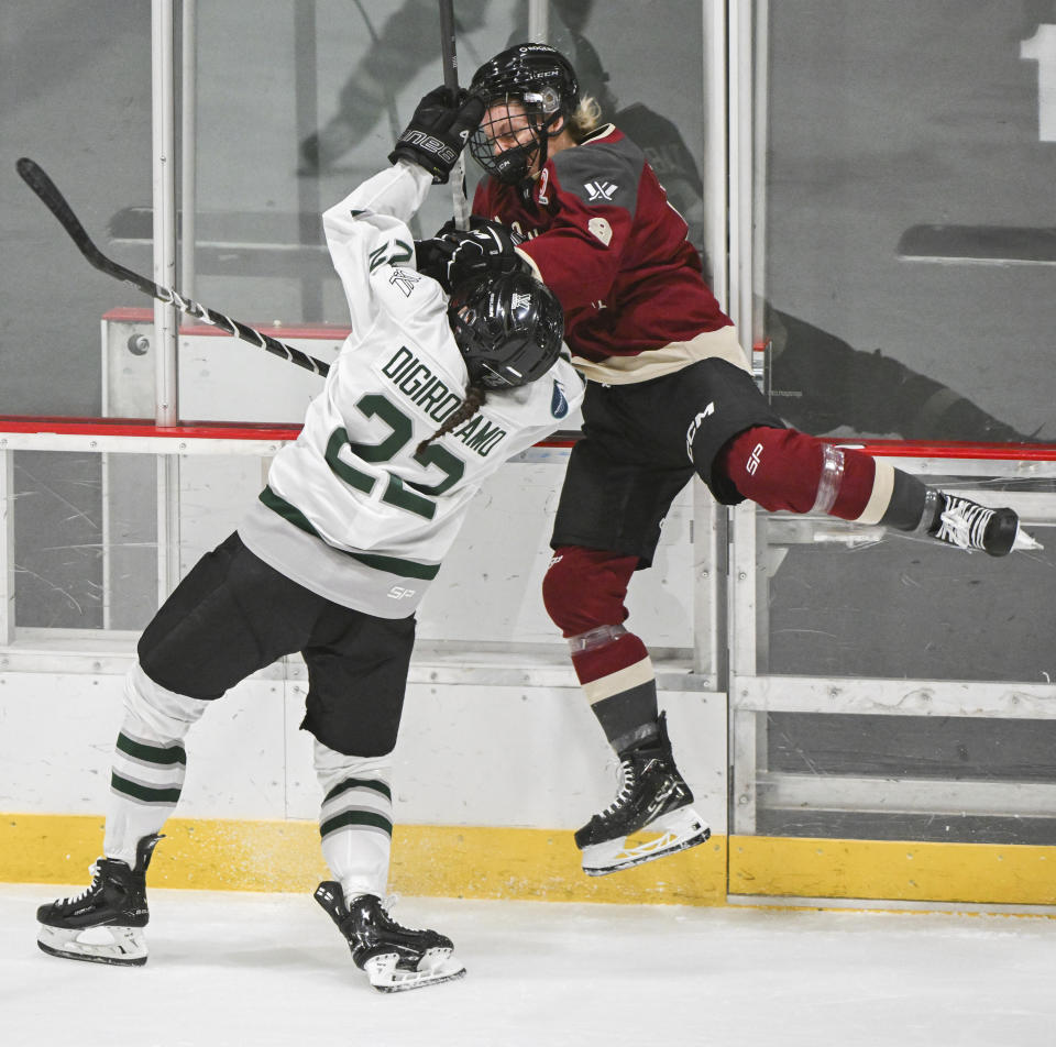 Boston's Jessica Digirolamo (22) checks Montreal's Kati Tabin, right, during third-period PWHL hockey game action in Montreal, Saturday, March 2, 2024. (Graham Hughes/The Canadian Press via AP)