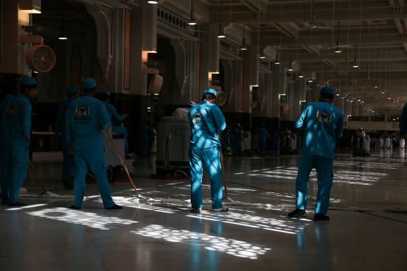 Cleaners swipe the floor, following the outbreak of the coronavirus, at the Grand mosque in the holy city of Mecca