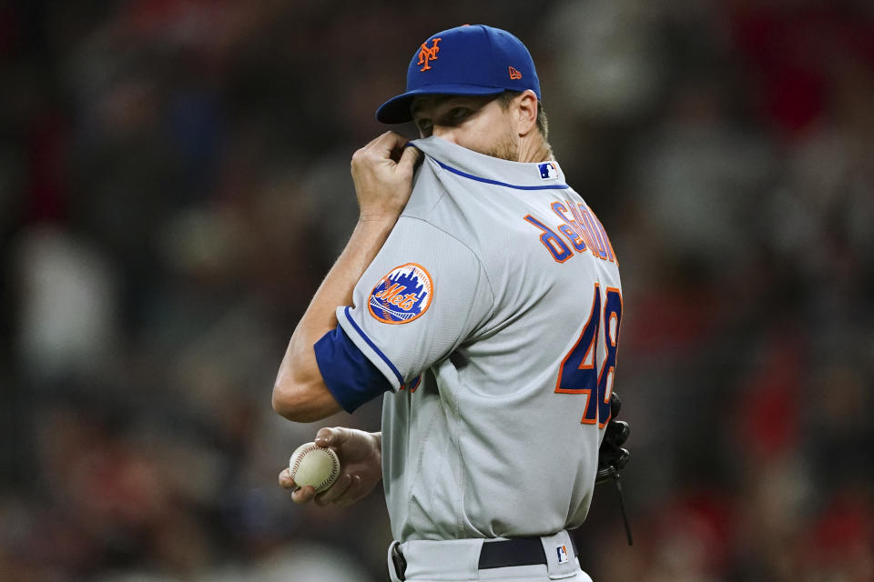 New York Mets starting pitcher Jacob deGrom wipes his face after allowing a solo home run to Atlanta Braves' Matt Olson during the second inning of a baseball game Friday, Sept. 30, 2022, in Atlanta. (AP Photo/John Bazemore)