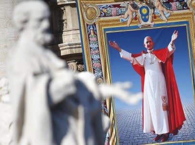 FILE PHOTO: The tapestry with the image of Pope Paul VI is unveiled as Pope Francis celebrates the mass for his beatification in St. Peter's square at the Vatican October 19, 2014. REUTERS/Tony Gentile