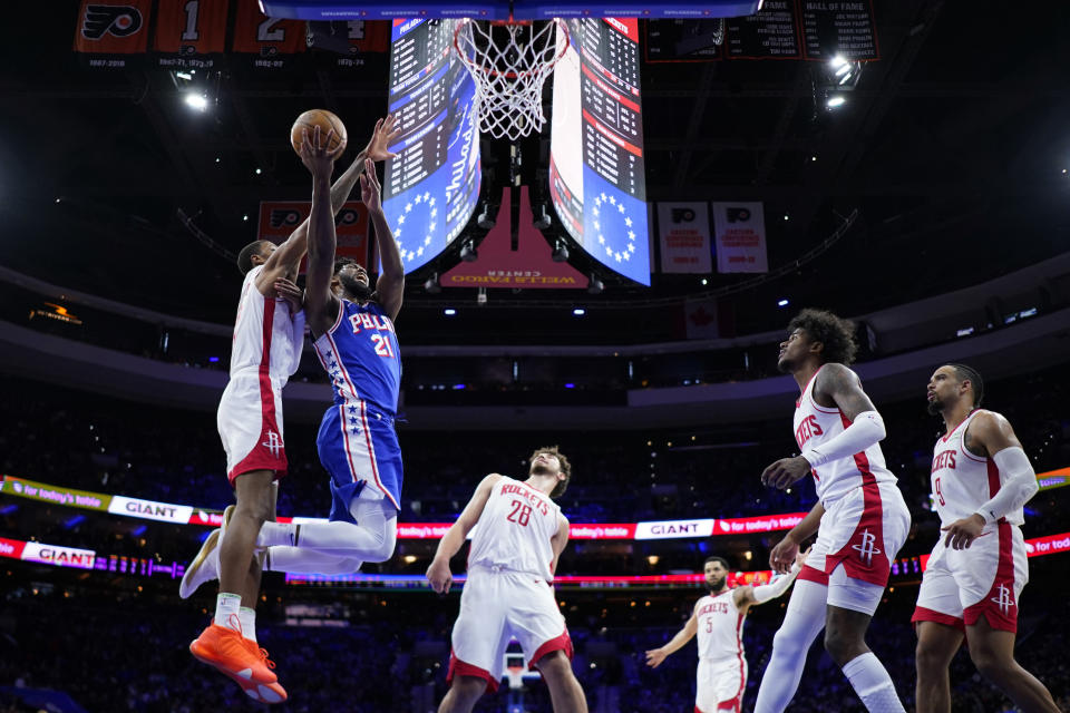 Philadelphia 76ers' Joel Embiid, second from left, goes up for a shot against Houston Rockets' Jabari Smith Jr., from left, as Alperen Sengun, Fred VanVleet, Jalen Green and Dillon Brooks look on during the second half of an NBA basketball game, Monday, Jan. 15, 2024, in Philadelphia. (AP Photo/Matt Slocum)