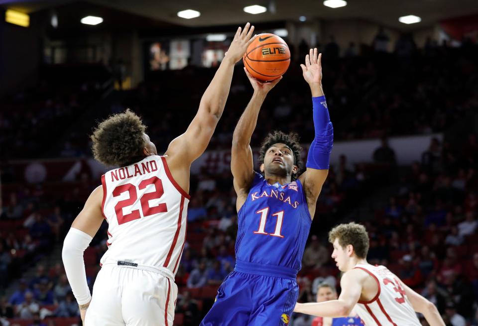 Kansas' Remy Martin (11) shoots as Oklahoma's C.J. Noland (22) defends during the first half of Tuesday's game at Norman, Okla.