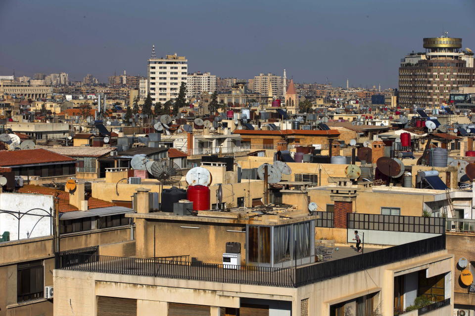 FILE - In this Feb. 28, 2016 file photo a Syrian boy plays soccer on the roof of a building in Damascus, Syria. A new Syrian law empowering the government to confiscate property is threatening to leave refugees stuck in Europe with no homes to return to. (AP Photo/Hassan Ammar, file)