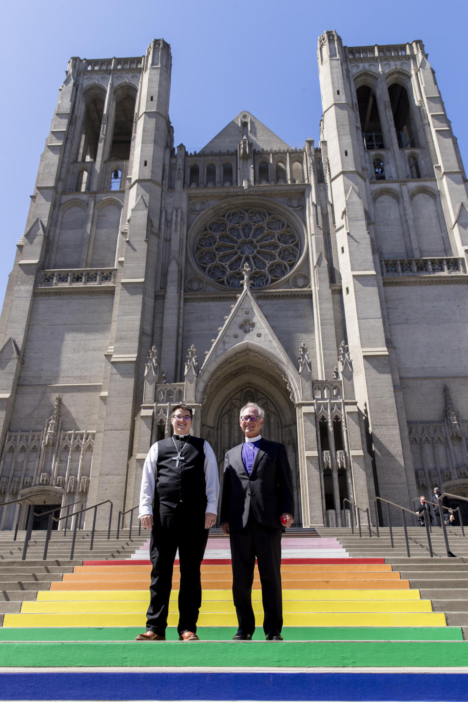 Bishop Megan Rohrer, left, and Bishop Marc Andrus stand on the rainbow steps before Bishop Rohrer's installation ceremony at Grace Cathedral in San Francisco, Saturday, Sept. 11, 2021. Rohrer is the first openly transgender person elected as bishop in the Evangelical Lutheran Church of America. (AP Photo/John Hefti)