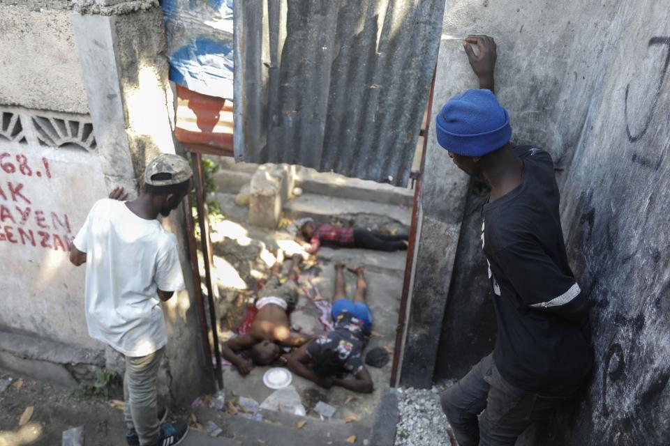 People look at the the bodies of three persons shot dead after an overnight shooting in the Pétion Ville neighborhood of Port-au-Prince, Haiti, Monday, April 1, 2024.(AP Photo/Odelyn Joseph)