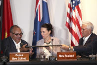 U.S. Vice President Mike Pence, right, passes a proclamation to Papua New Guinea's Prime Minister Peter O'Neill, left, as New Zealand's Prime Minister Jacinda Ardern watches during a signing ceremony for the Papua New Guinea Electrification Partnership at APEC Haus in Port Moresby, Papua New Guinea, Sunday, Nov. 18, 2018. (AP Photo/Mark Schiefelbein)