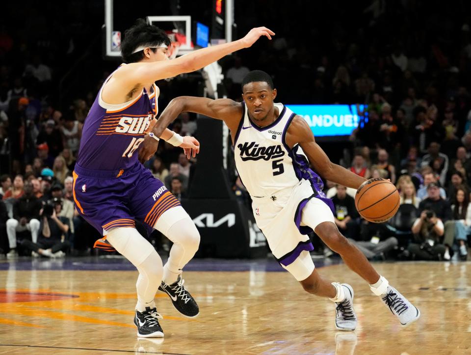 Sacramento Kings guard De'Aaron Fox (5) drives against Phoenix Suns forward Yuta Watanabe (18) in the second half at Footprint Center in Phoenix on Dec. 8, 2023.
