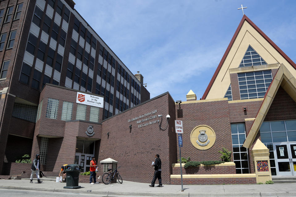 In this June 7, 2020, photo, people walk outside the Salvation Army's Harbor Light Center, Minneapolis' largest homeless shelter, where George Floyd once worked as a security guard. (AP Photo/Julio Cortez)