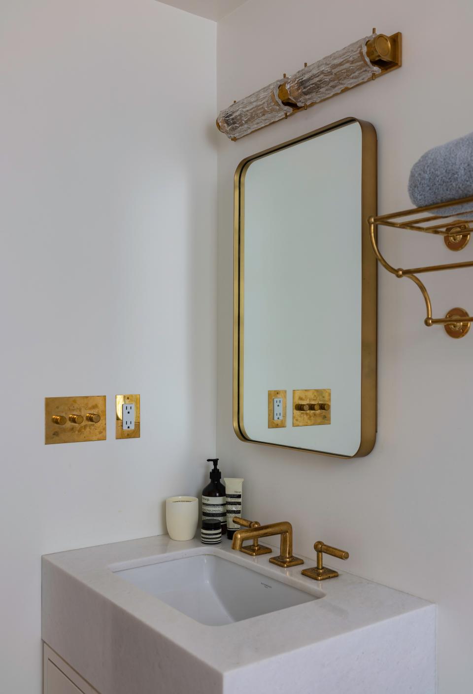 In the bathroom, the hardware, fixtures, and lighting are all by Waterworks, the medicine cabinet is by RH, and the walls are painted Simply White by Benjamin Moore.