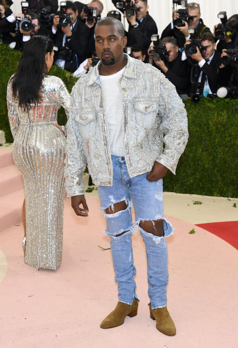 Kanye West in jeans and a shiny biker jacket 