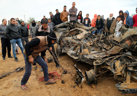 Palestinians inspect the remains of a vehicle that was destroyed in an Israeli air strike, in Khan Younis in the southern Gaza Strip November 12, 2018. REUTERS/Suhaib Salem