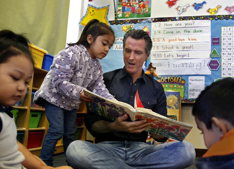 Gov. Gavin Newsom and kindergartner Priscilla Ramirez looks over the book Planting a Rainbow, by Lois Ehlert during his visit to the Ethel I. Baker Elementary School in Sacramento, Calif., Monday, Oct. 7, 2019. During his visit Newsom took the occasion to sign legislation to place a $15 billion bond measure on the March 2020 ballot for school construction and modernization projects. (AP Photo/Rich Pedroncelli, Pool)