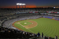 FILE - In this Aug. 29, 2019, file photo, the sun sets behind Citi Field during a baseball game between the New York Mets and the Chicago Cubs in New York. Major League Baseball players ignored claims by clubs that they need to take additional pay cuts, instead proposing they receive a far higher percentage of salaries and a commit to a longer schedule as part of a counteroffer to start the coronavirus-delayed season. (AP Photo/Kathy Willens, File)