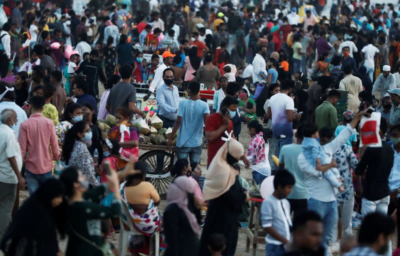 People walk or stand at a crowded beach amidst the spread of the coronavirus disease (COVID-19) in Mumbai