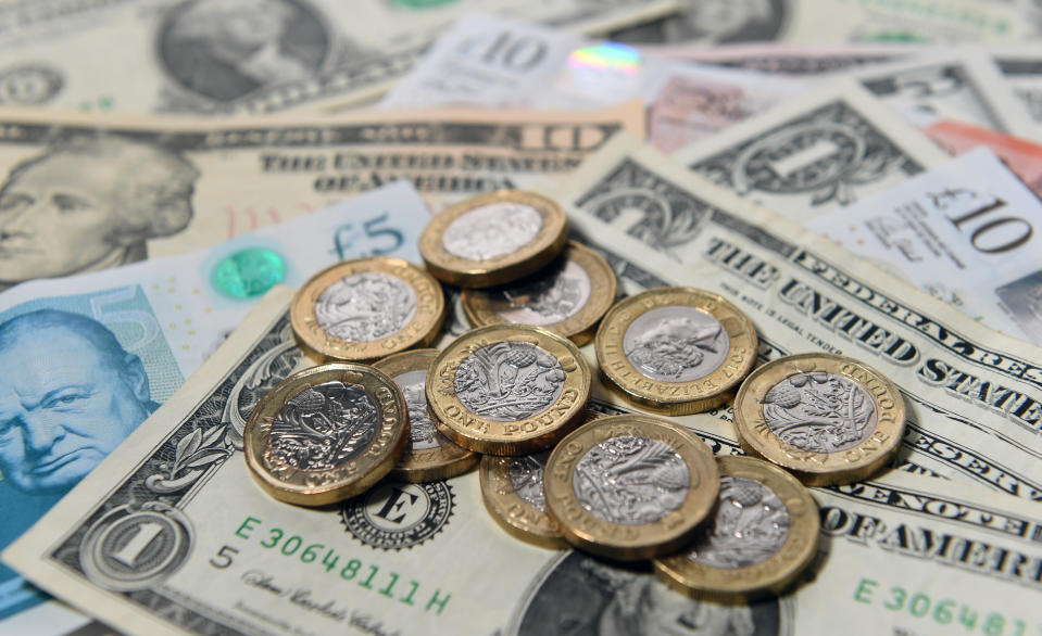 United States dollar bills amongst UK pound sterling coins and bank notes.