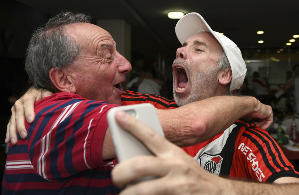 River Plate soccer fans celebrate their team's third goal against Boca Juniors, made during overtime, bringing the score to 3-1, as they watch on TV the Copa Libertadores final at their team's museum in Buenos Aires, Argentina, Sunday, Dec. 9, 2018. The South American decider was transferred from Buenos Aires to Madrid, Spain after River fans attacked Boca's bus on Nov. 10 ahead of the second leg. (AP Photo/Gustavo Garello)