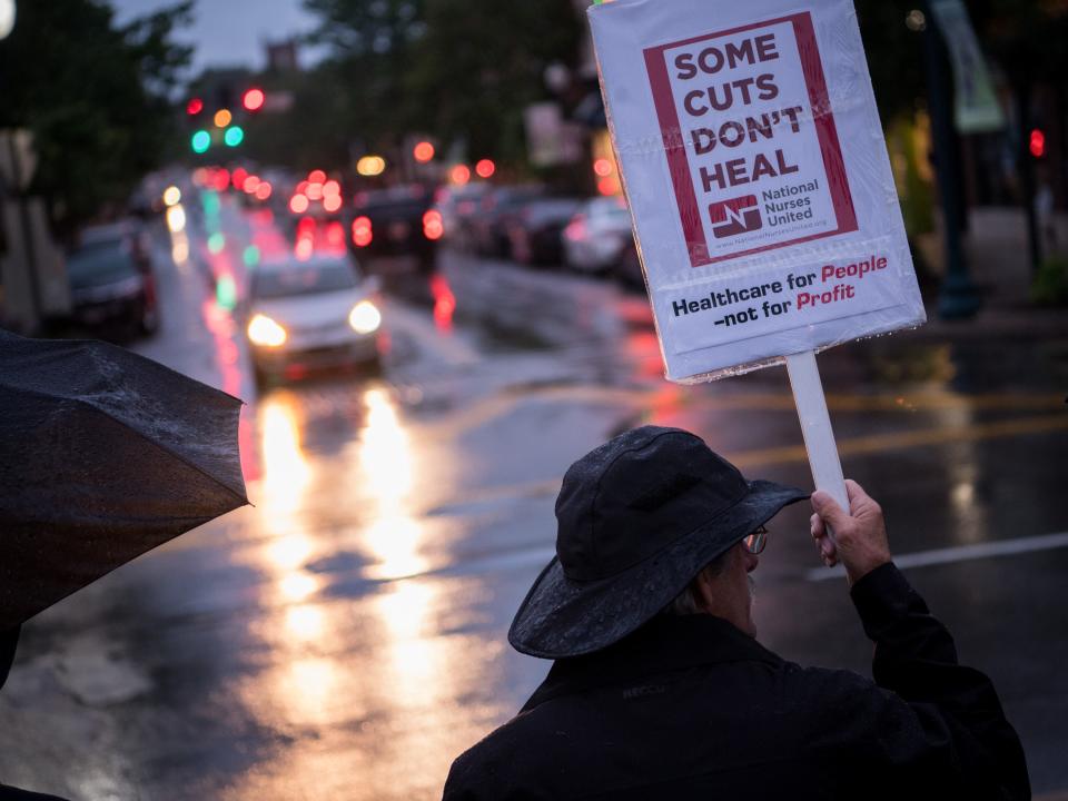 Mark Russell holds a sign during a candlelight vigil at Public Square in Franklin on May 4, 2017. The vigil was held to shine a light on Tennessee residents at risk of losing insurance coverage or facing increased costs as a result of the vote on the American Health Care Act.