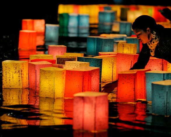 A woman floats a paper lantern on the Motoyasu River in Hiroshima to mark the 65th anniversary of the World War II atomic bombing of the city. Representatives from more than 70 nations, including for the first time the United States, joined tens of thousands at the emotional event.