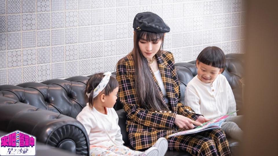 謝金燕（中）陪伴小孩看故事書。（圖／TVBS）