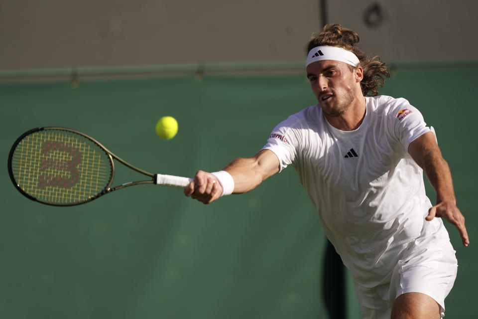 El griego Stefanos Tstisipas regresa una bola al austriaco Dominic Thiem en el duelo de primera ronda en Wimbledon el miércoles 5 de julio del 2023. (AP Foto/Alberto Pezzali)