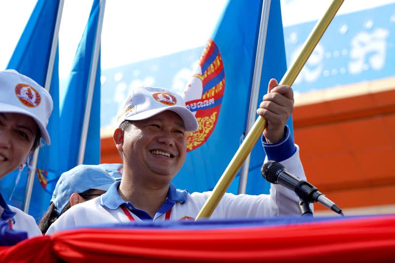 General Hun Manet, son of Cambodia's Prime Minister Hun Sen holds a party flag as he attends a kickoff of an election campaign rally for the upcoming national election in Phnom Penh
