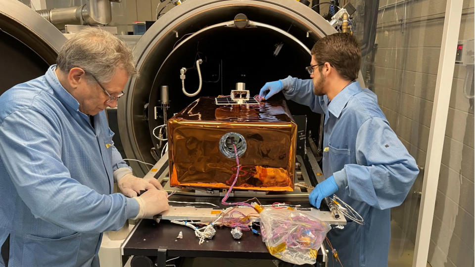 two people in a lab adjust the settings on a piece of scientific equipment during a test