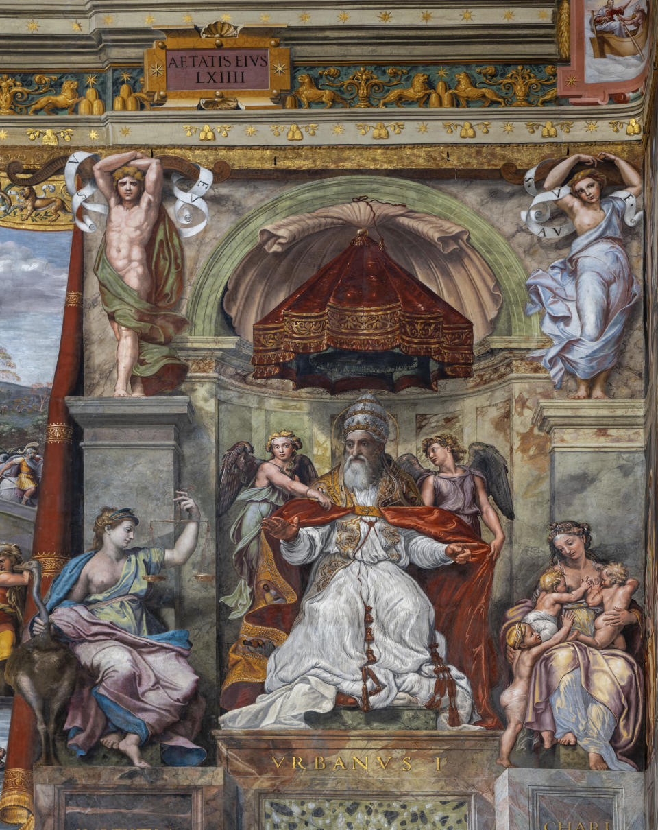 A feminine figure painted in oil and known as 'Allegory of Friendship', right, is seen as part of a fresco depicting pope Clemens I in the Constantine Hall at the Vatican Museums, Wednesday, May 3, 2020.The Vatican Museums announced last month that after restorations they have determined that two of the female figures in the Hall of Constantine that are painted in oil were done by Raphael himself and not by his workshop. (AP Photo/Domenico Stinellis)