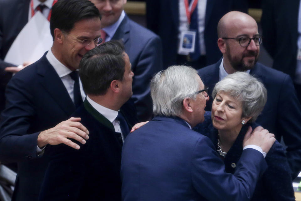 European Commission President Jean-Claude Juncker, center, greets British Prime Minister Theresa May, right, during a round table meeting at an EU summit in Brussels, Thursday, March 21, 2019. British Prime Minister Theresa May is trying to persuade European Union leaders to delay Brexit by up to three months, just eight days before Britain is scheduled to leave the bloc. (Aris Oikonomou, Pool Photo via AP)