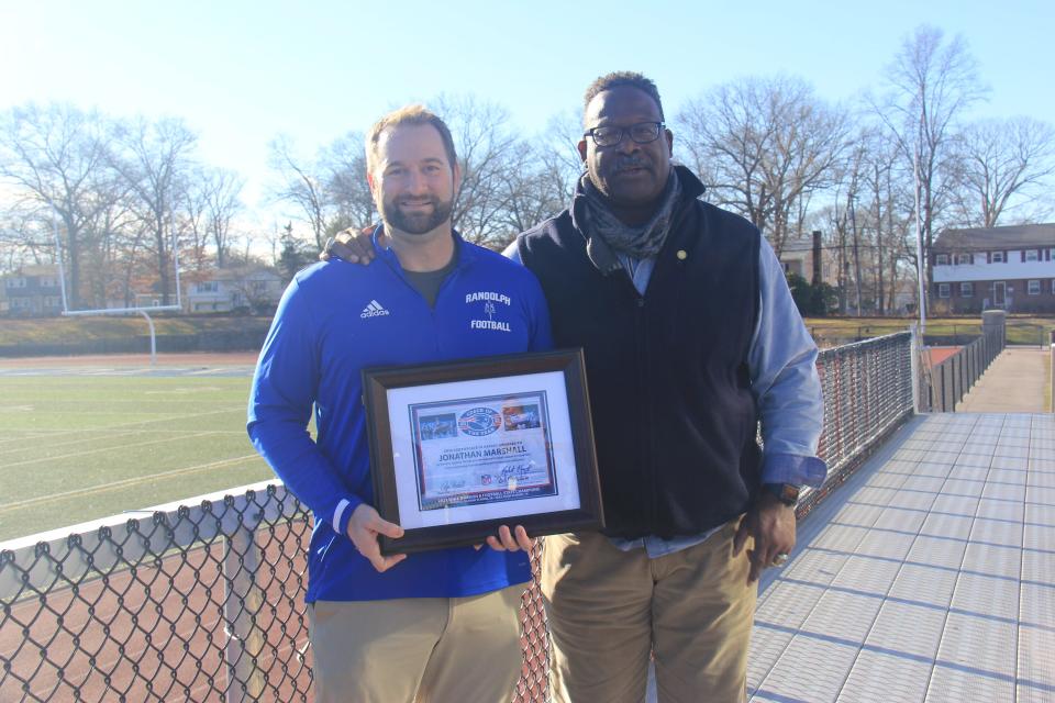 Former New England Patriots linebacker and NFL Hall of Famer Andrew Tippett presented Randolph High football coach Jonathan Marshall with the Patriots High School Football Coach of the Year Award.