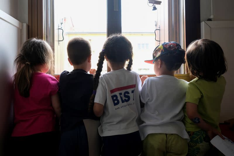 Children pose by a window inside a nursery of Cartigliano