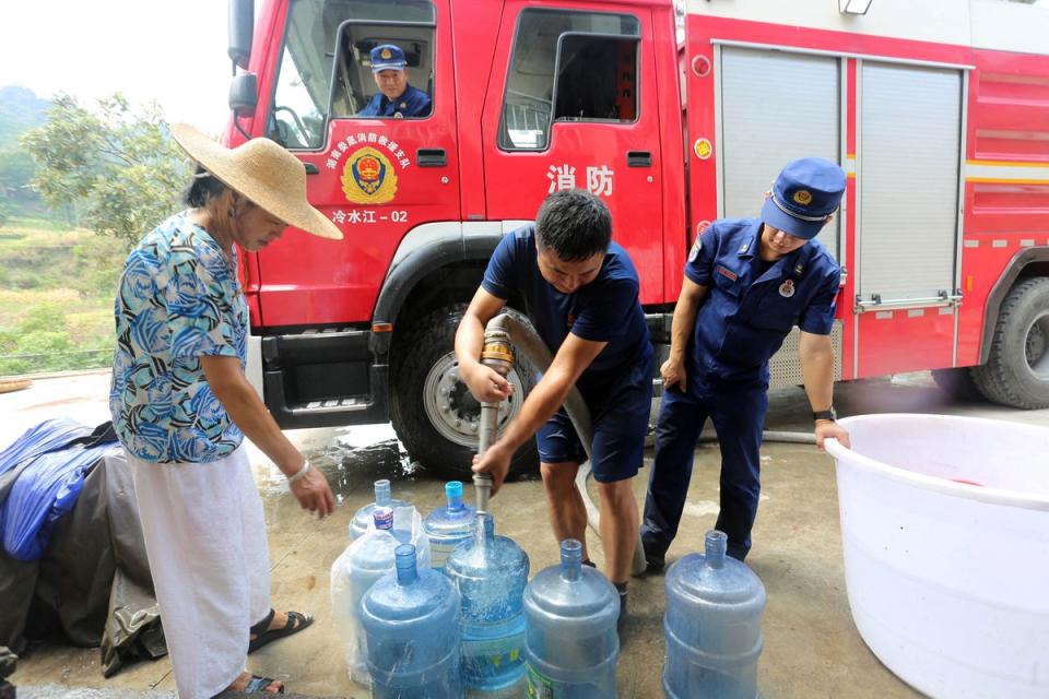 Firefighters delivering water to residents due to a shortage amid heatwave conditions, in Loudi in China’s central Hunan province (AFP via Getty Images)