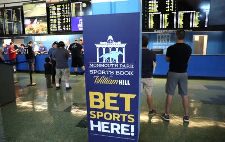 Gamblers place bets on sports at Monmouth Park Sports Book by William Hill, shortly after the opening of the first day of legal betting on sports in Oceanport, New Jersey, U.S., June 14, 2018. REUTERS/Mike Segar