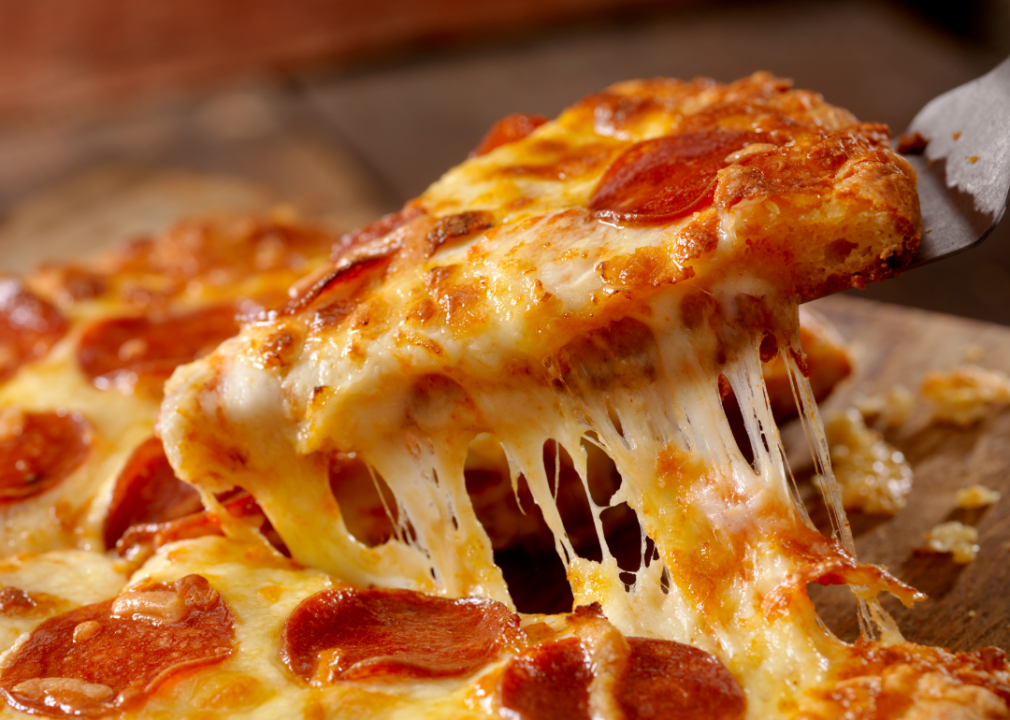 Slice of pizza being pulled from a pan.