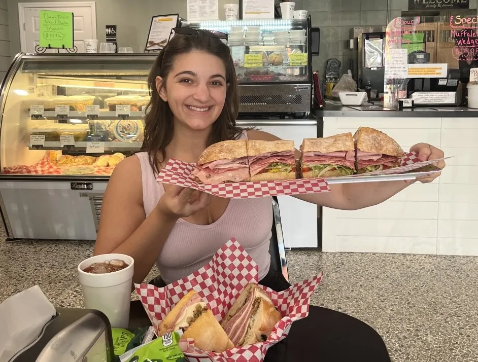 Caroline Hebert with a large sandwich from Rosie's Bakery in Daytona Beach.