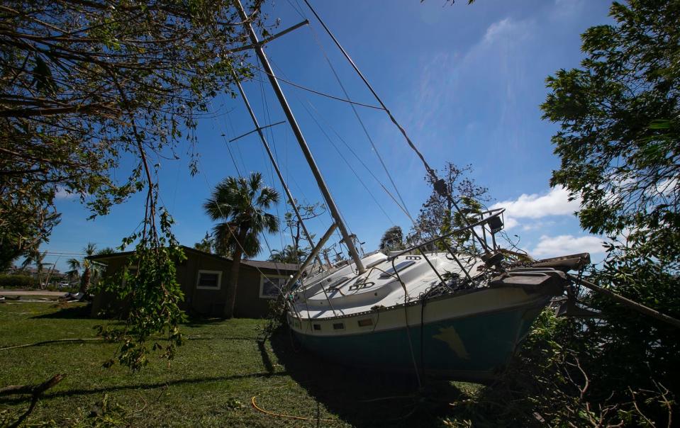 A large sailboat sits behind a waterfront home near the Cape Coral Yacht Club. Hurricane Ian tossed thousands of boats across the Southwest Florida landscape.