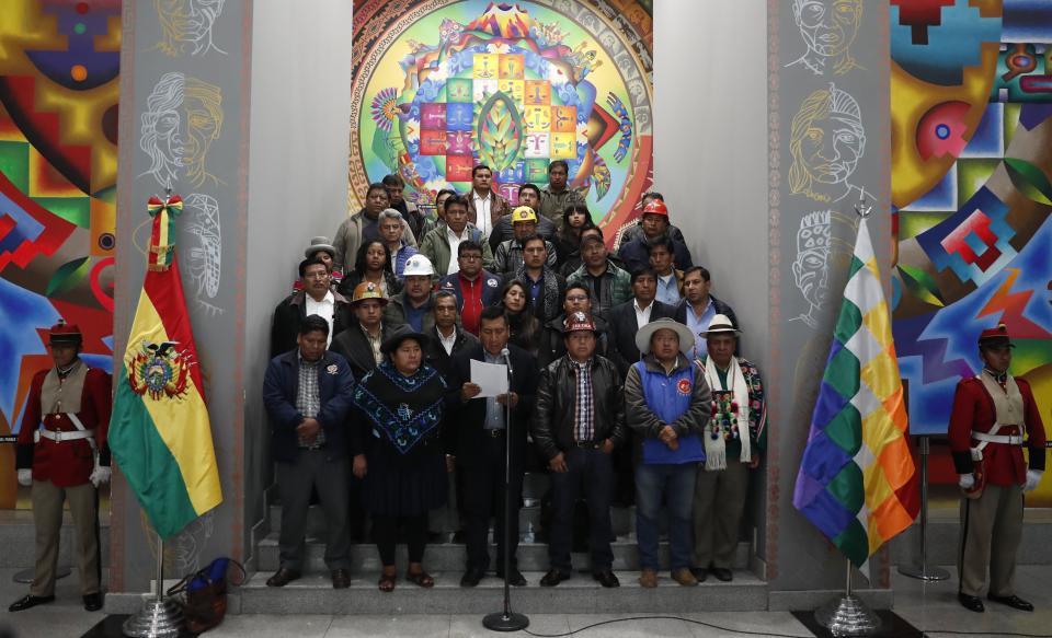 Social leader Freddy Mamani, accompanied by other social leaders who support President Evo Morales, reads a document where they announce their mobilization to defend the official results of Sunday’s general election, at the Presidential Palace in La Paz, Bolivia, Tuesday, Oct. 22, 2019. Rioting broke out in parts of Bolivia among opponents of President Evo Morales after electoral authorities announced that a resumed vote count after a day-long delay put the leader close to avoiding a runoff in his bid for a fourth term. (AP Photo/Jorge Saenz)